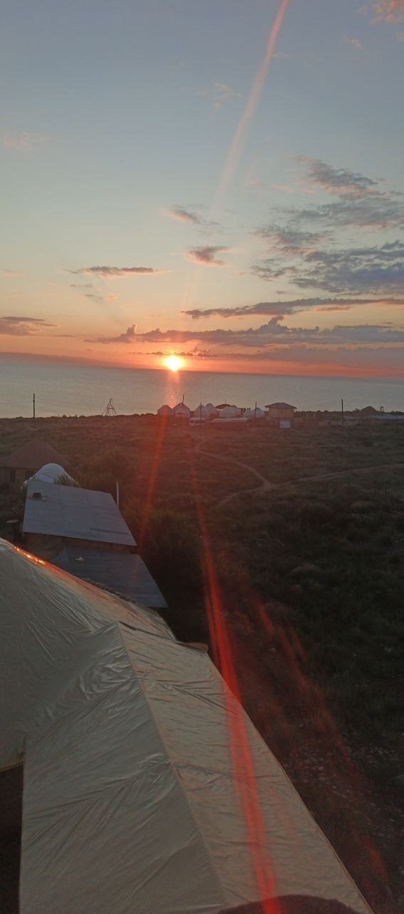 Sunrise above a yurt camp beside a lake